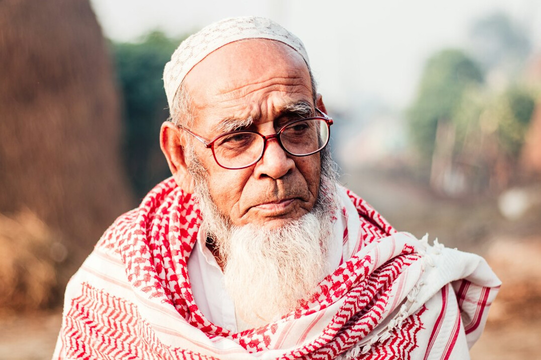 Senior man with glasses and white beard smiling portrait