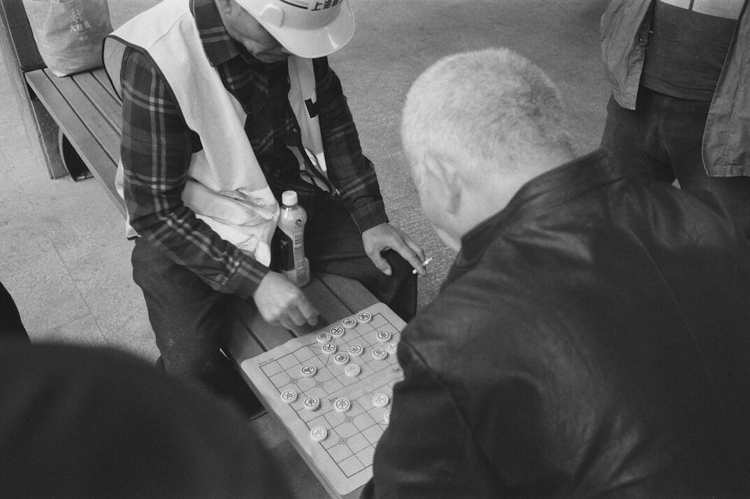 Seniors playing a board game around a table laughing
